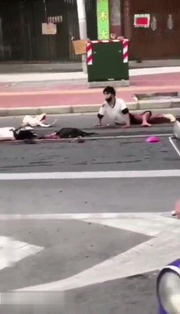 Horribly injured man tries to reach for his dead partner