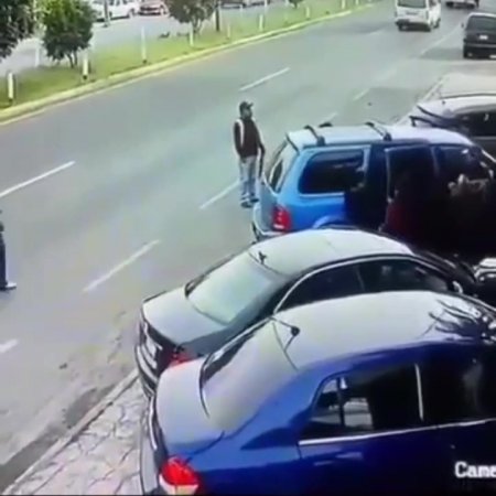 Man Sandwiched Between Reversing Car And Passing Truck