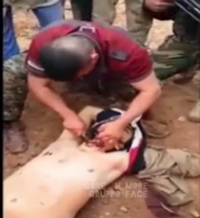 A Group Of Armed Men Is Trying To Cut Off The Head Of A Dead Enemy