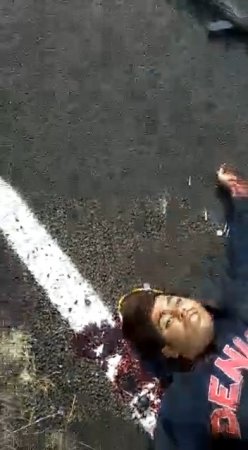 A Dead Man Lying On The Road Is Cut Off His Head With A Pocket Knife