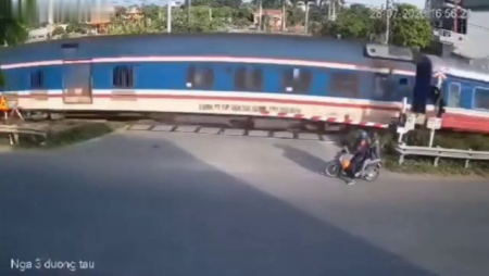 Elderly Couple On A Motorcycle VS Train. Vietnam