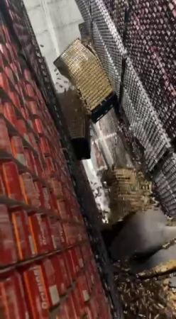 Workers let fall thousands of cans of soda