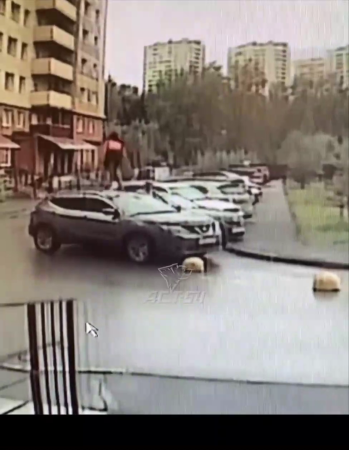 Because Of A Quarrel With Her Husband, A Woman Broke The Windshield Of Her Husband's Car With Dumbbells And Jumped On The Roof. Novosibirsk, Russia