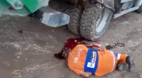 A Garbage Collector's Head Is Crushed Under The Lid Of A Garbage Collection Vehicle