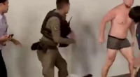 Thai Police Are Trying To Detain A Man Walking Down The Street In His Underpants