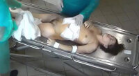 Dead Young Woman Being Dressed at Morgue